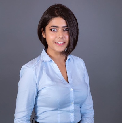 woman in blue button down smiling at camera