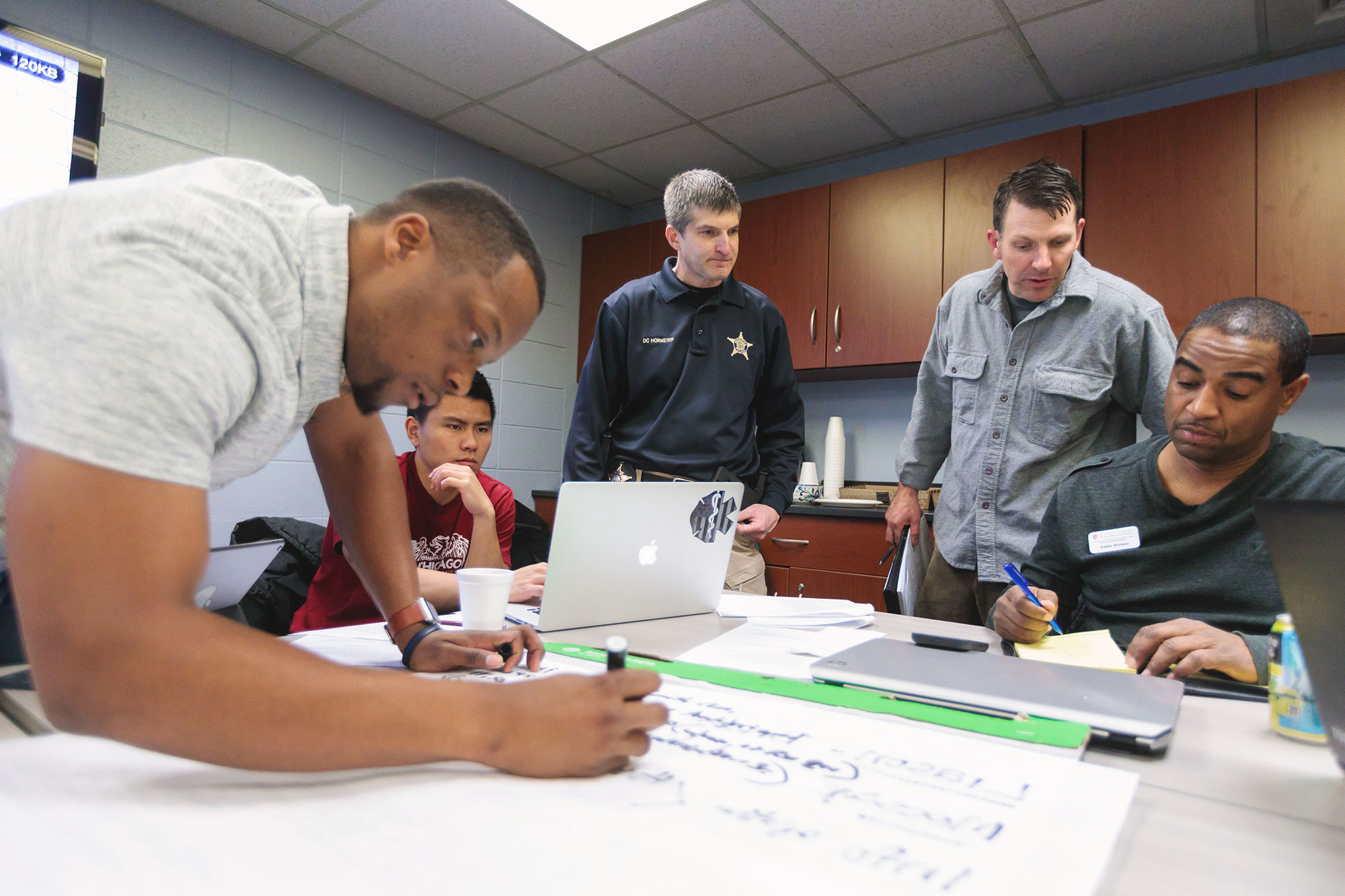 A group of people in a meeting room planning for a disaster drill.