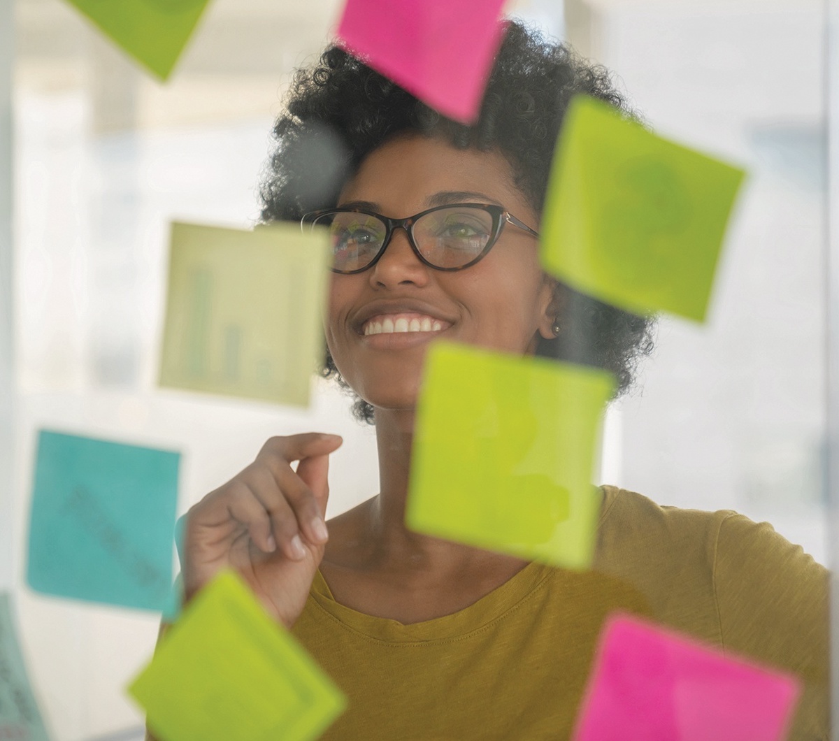 woman smiling in front of post it notes