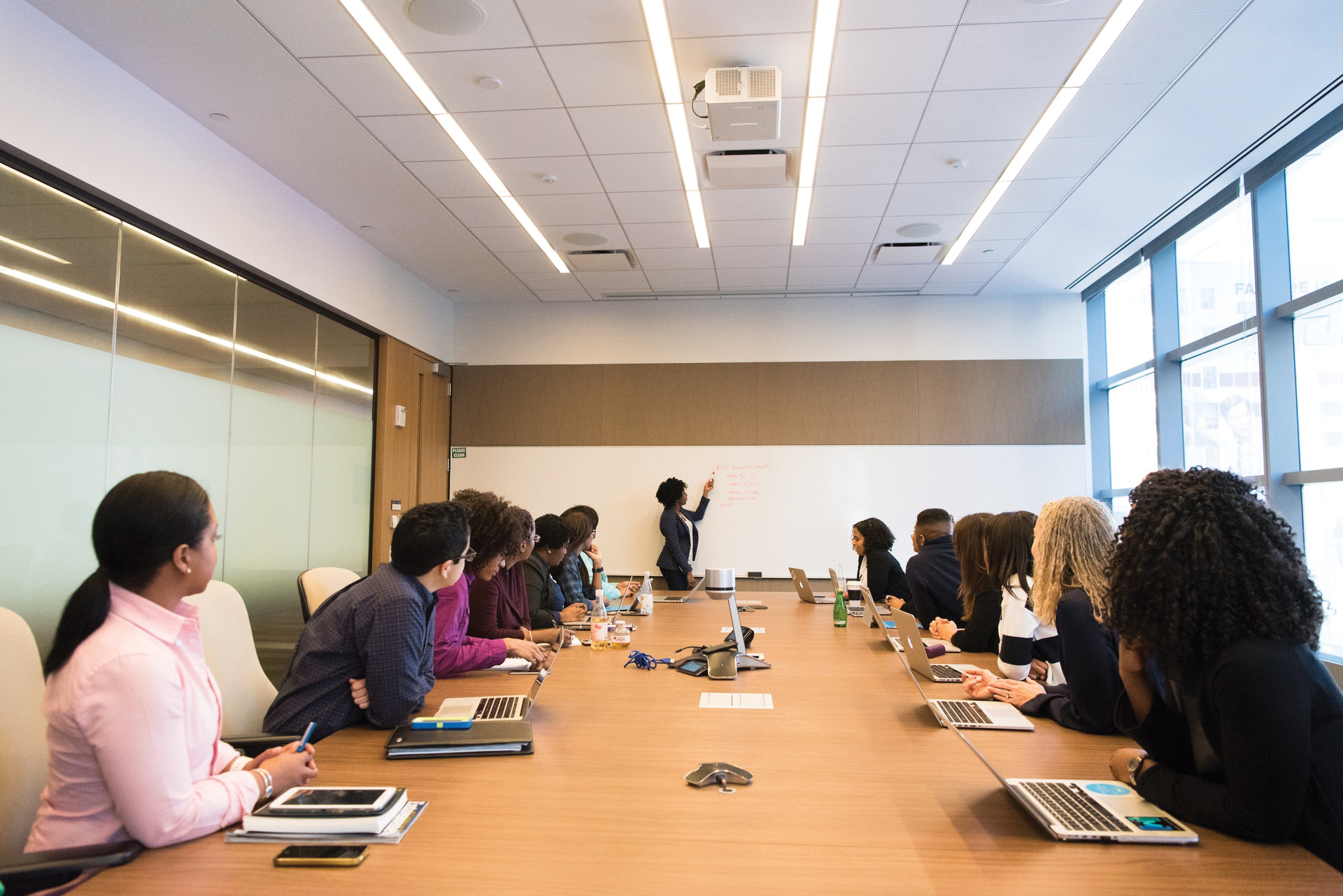 Woman talking at white board in conference room