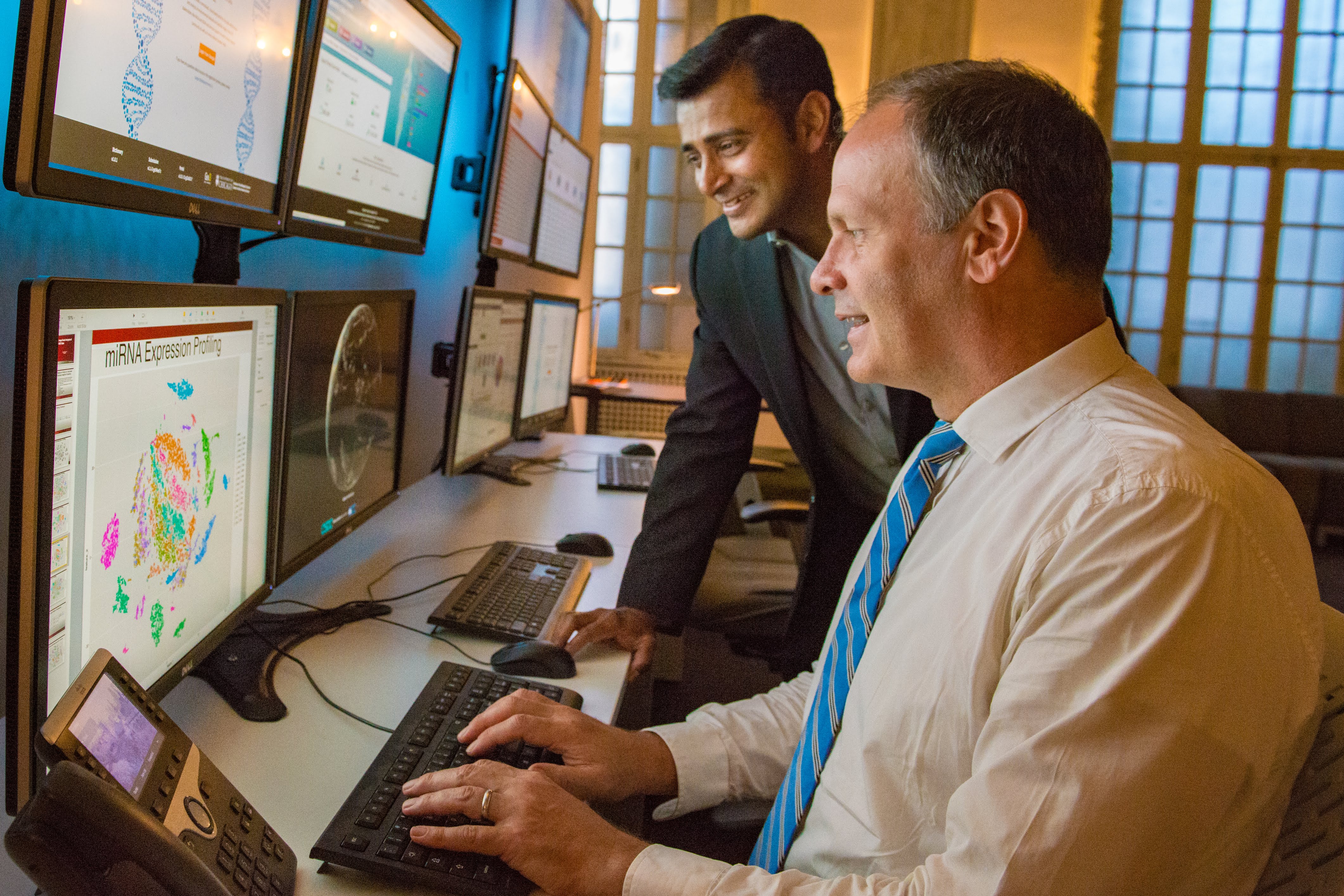 MScBMI Faculty and Students look over genomic data on a computer screen.