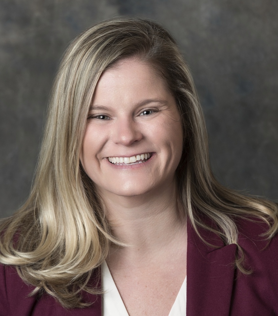 woman smiling in maroon suit