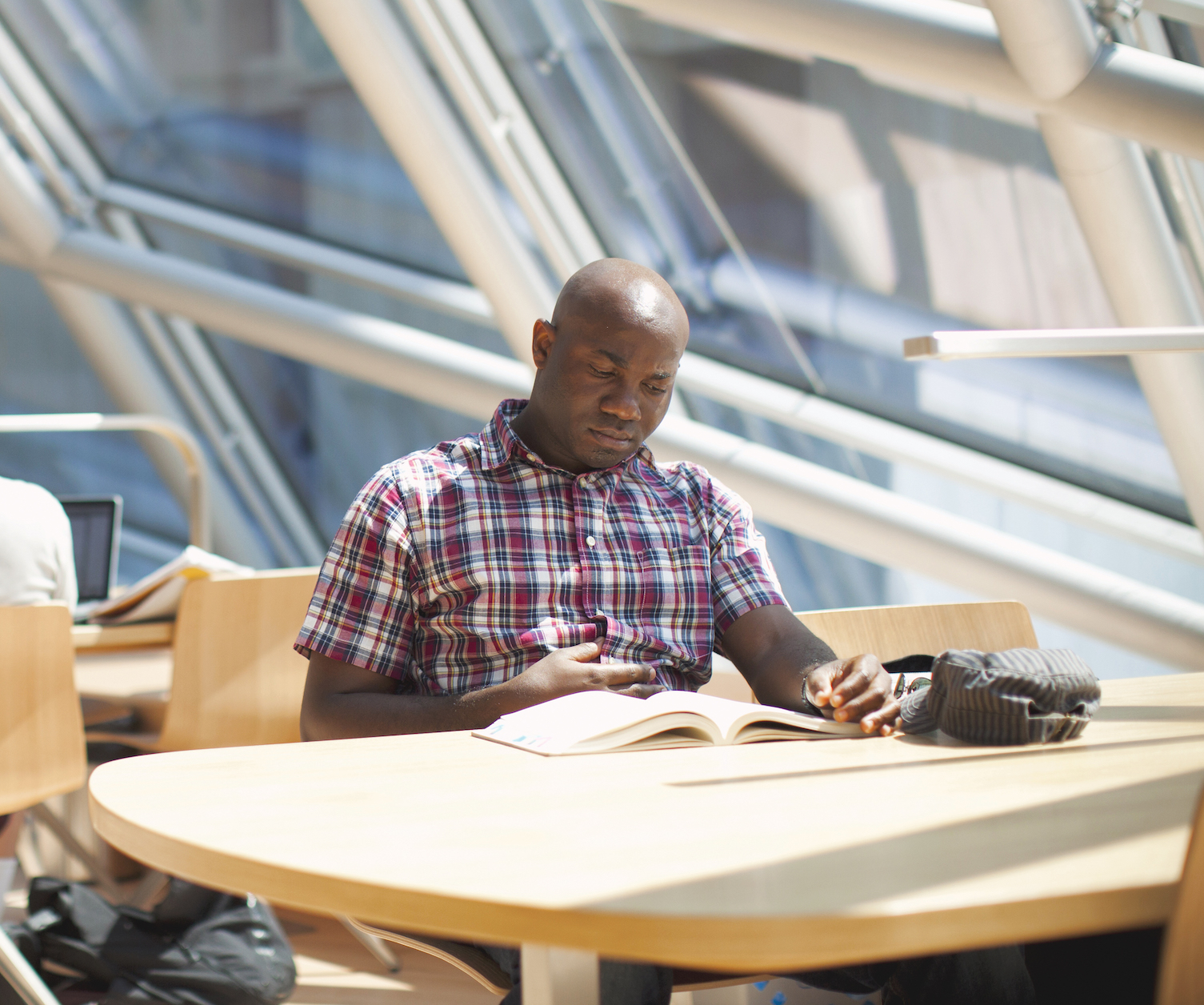 A Man sitting down reading a book at the UChicago campus.