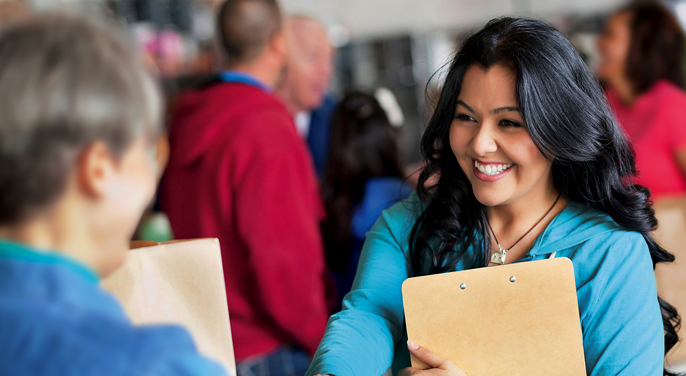 Two women shaking hands at a career fair.