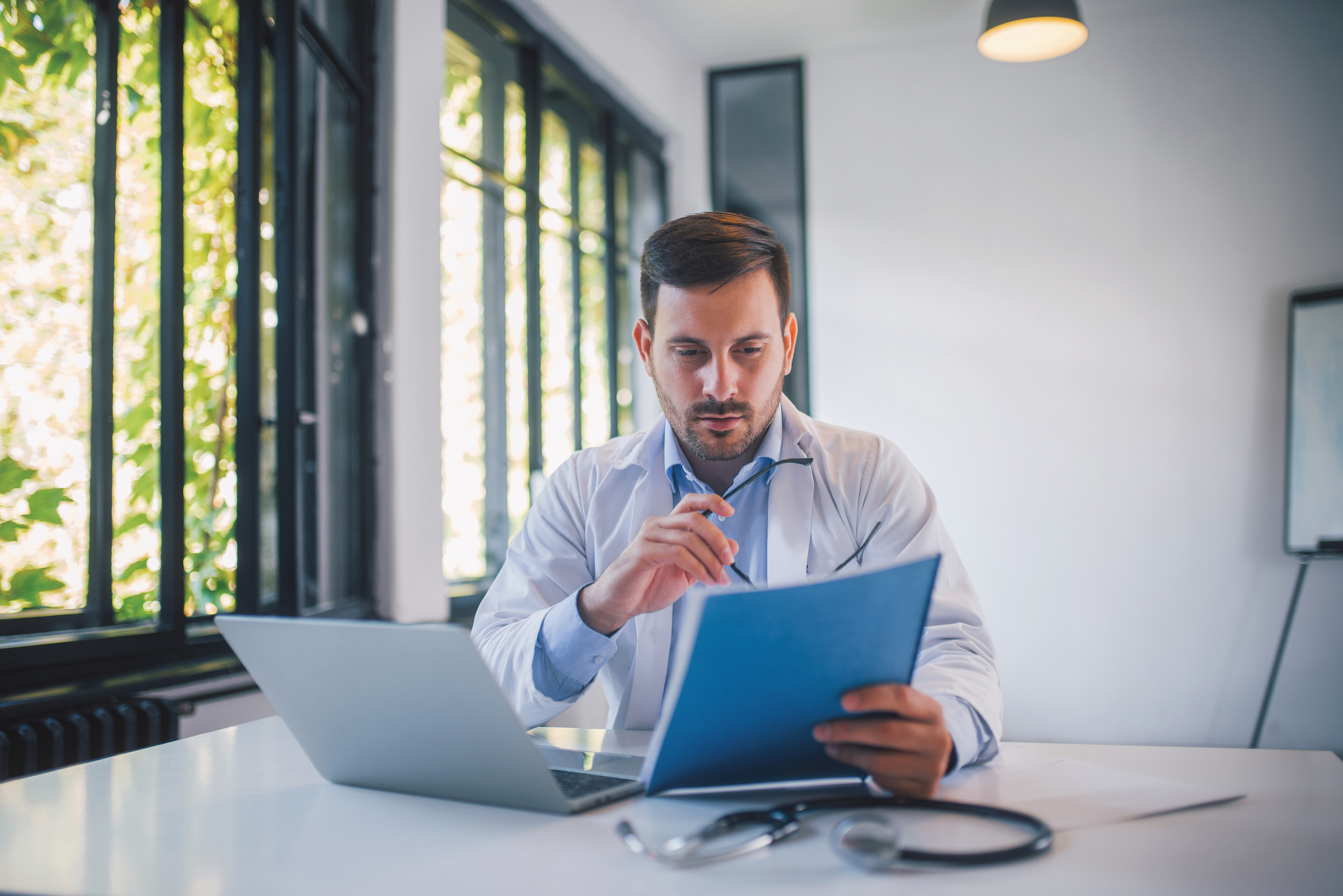 A medical professional reviews documents in his office.