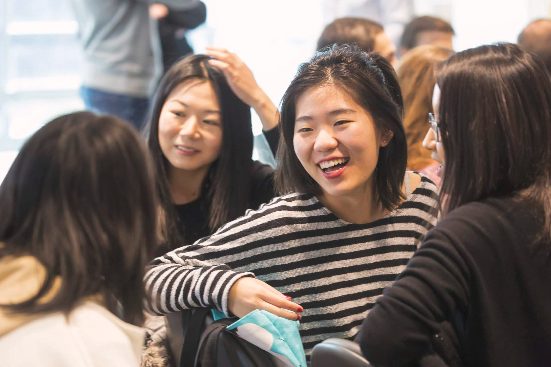 Students in a classroom laughing with one another.