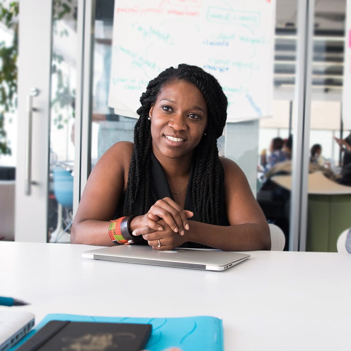 Woman sitting at a table in a conference room and smiling