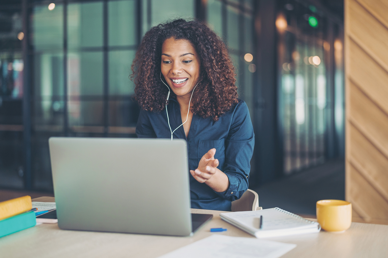 Woman with headphones in at computer.