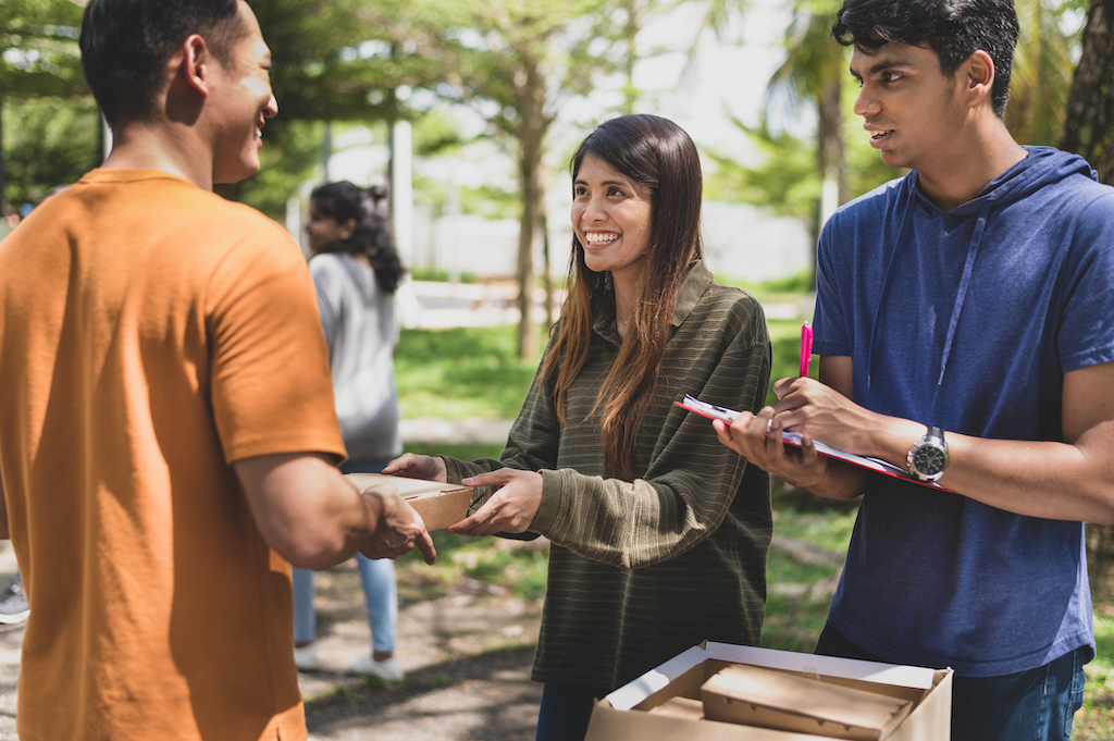 Volunteers giving out free packed of food during food drive.