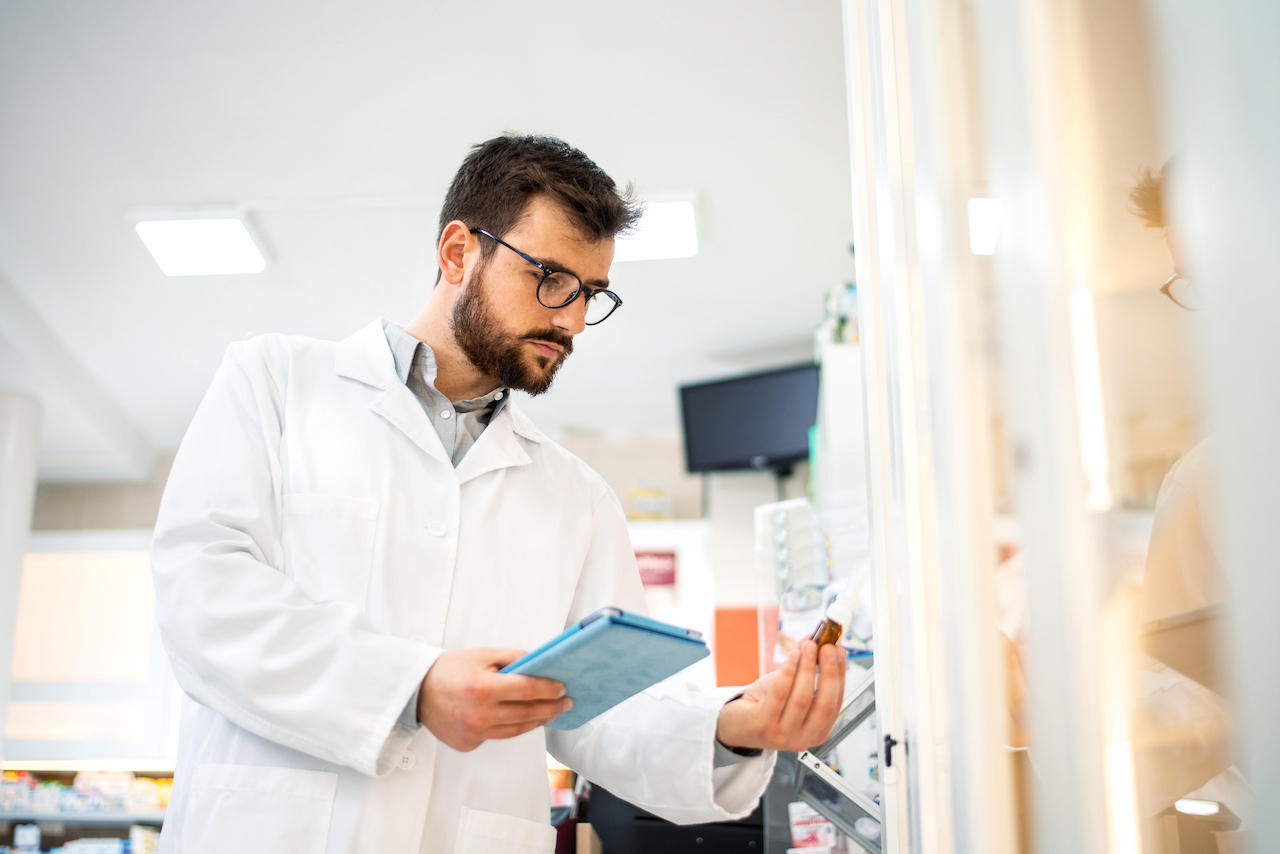 A healthcare professional looking at a digital tablet.