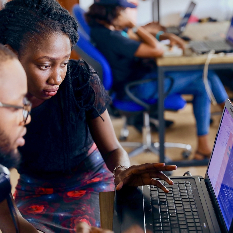 Two people working on code on a computer.