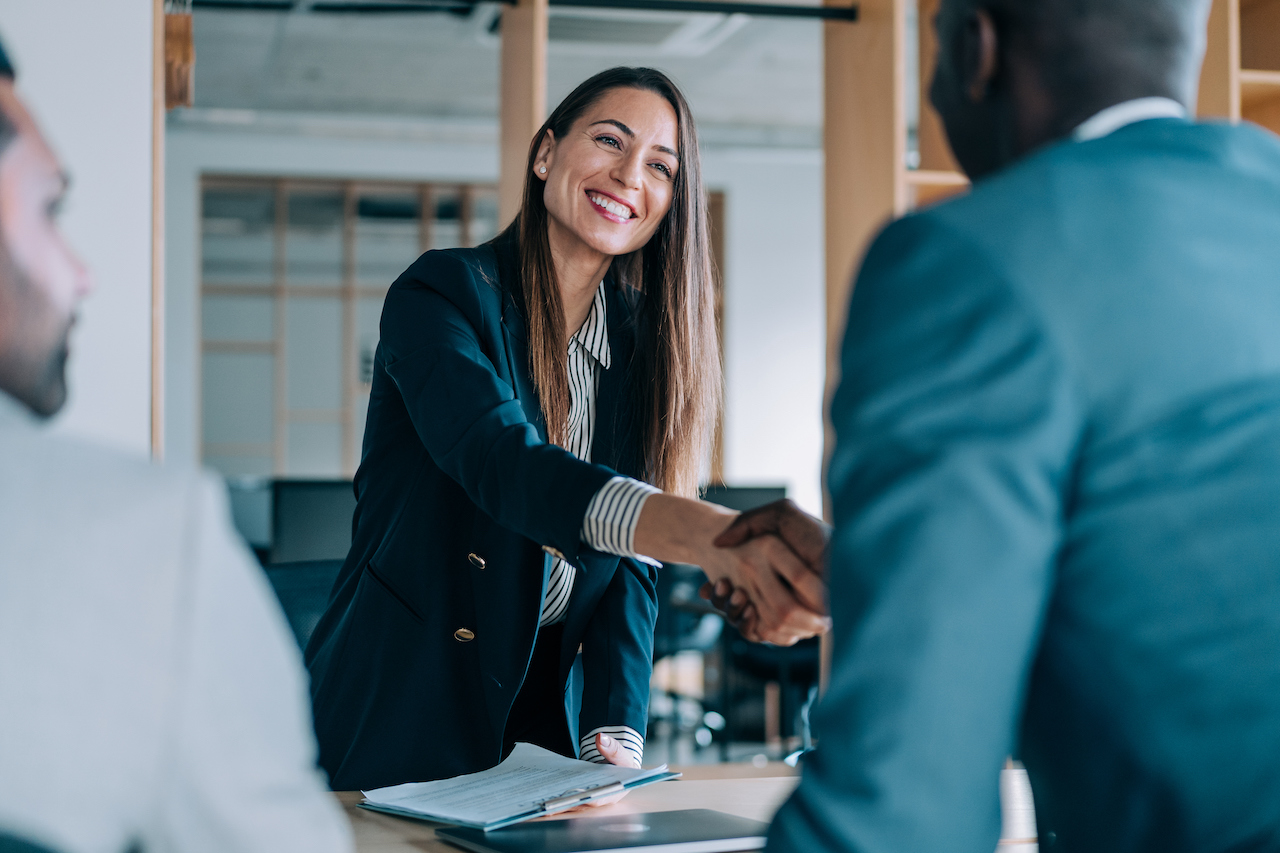 Business woman shaking hands with associate.