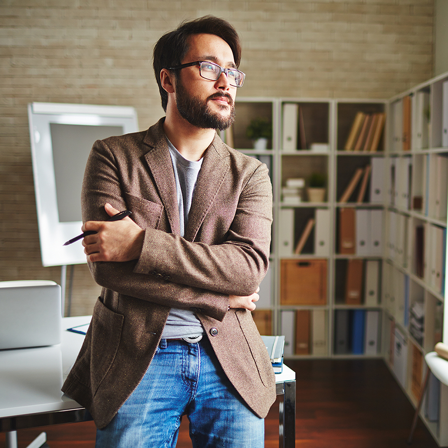 man standing in front of his desk thinking