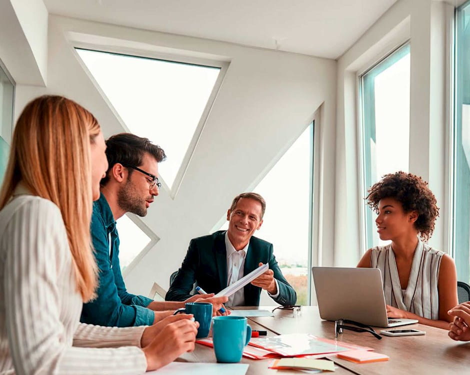 A group of C-Suite executives working around a table.