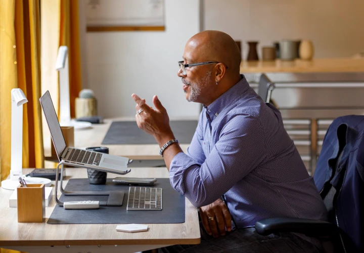 a person sitting at a desk having a consultation online