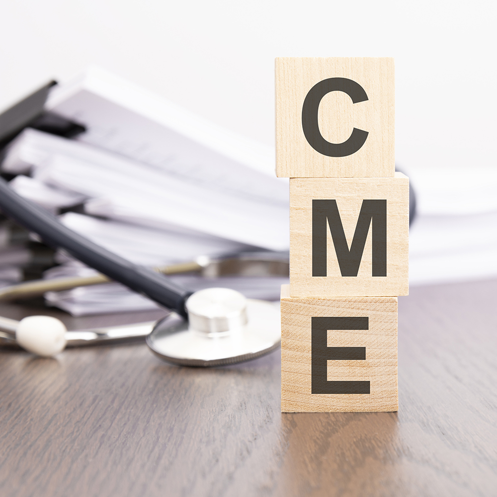 An image of blocks stacked to spell CME with a stethoscope beside them.