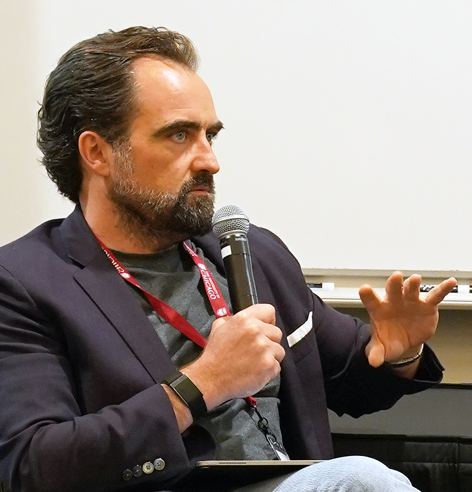 Dan Frailey sitting and speaking in front of a classroom