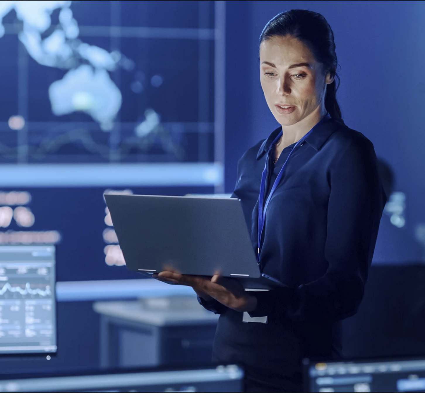 A woman standing and holding a laptop