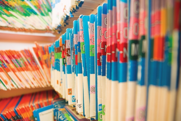 A row of medical files sit on a shelf. 