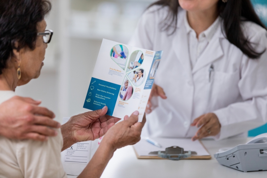 Senior woman examines pharmacy brochure.