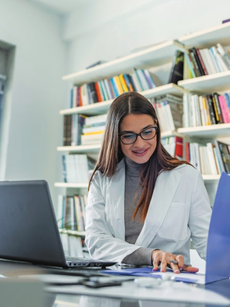 A medical professional reviews her notes in her office.