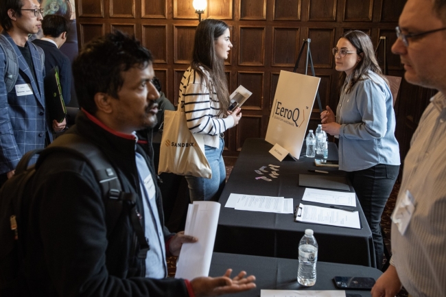 Jenna Theis (right, blue shirt), the director of operations at EeroQ Quantum Hardware, talks to an attendee at the 2024 Chicago Quantum Recruiting Forum.