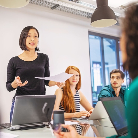 Woman standing at conference table talking