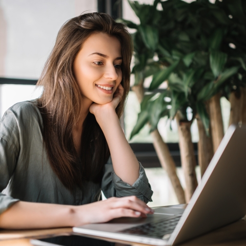 Student looking at her laptop and smiling