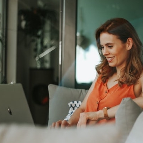 A women sitting in her living room browsing her laptop