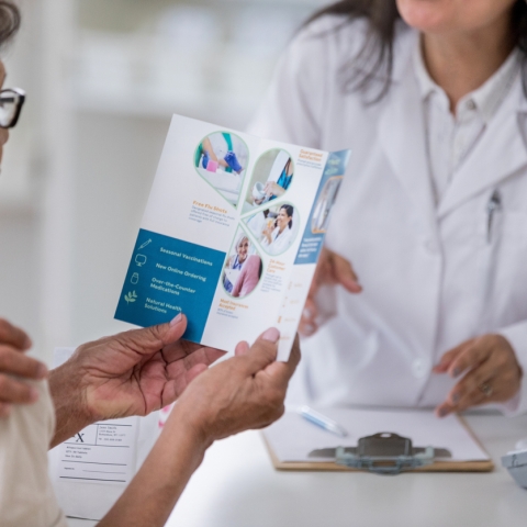 Senior woman examines pharmacy brochure.
