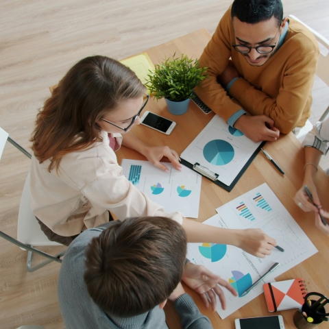 People working around a table and looking at data