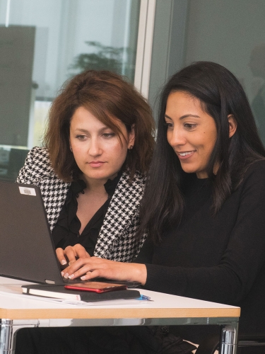 Executive Education students looking at a computer