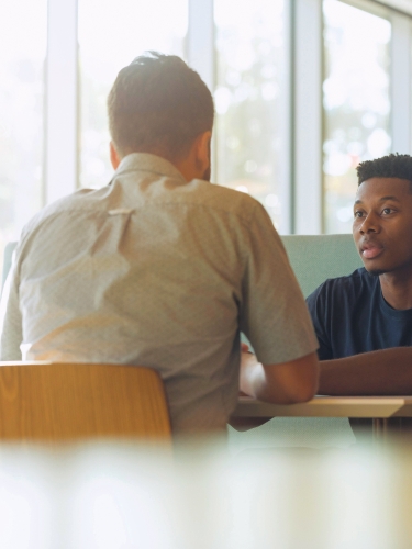 Two people sitting at table talking