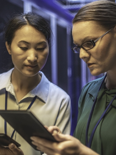 Two women monitoring a computer system.