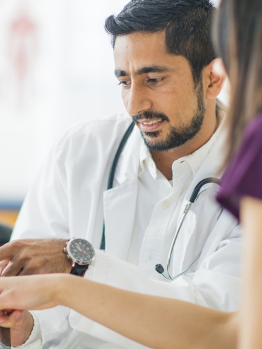 A doctor and nurse analyze a tablet.