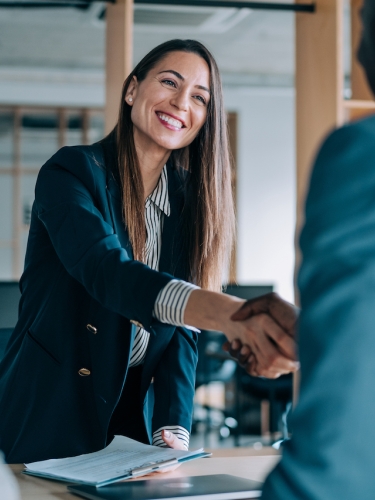 Business woman shaking hands with associate.