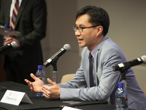 man sitting at table with microphone
