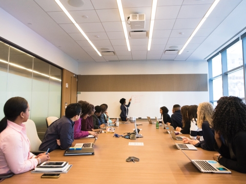 Woman talking at white board in conference room