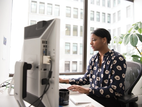 Woman at desk workin on a computer
