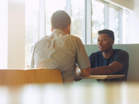 Two people sitting at table talking