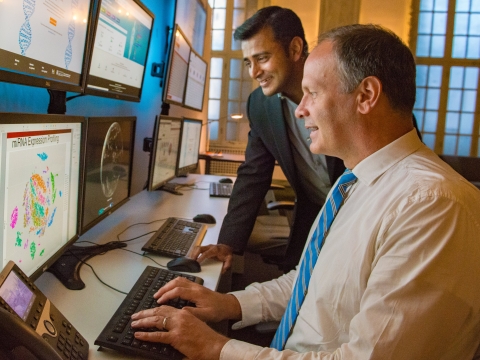MScBMI Faculty and Students look over genomic data on a computer screen.