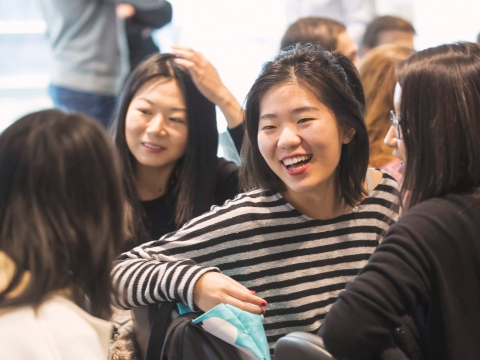 Students in a classroom laughing with one another.