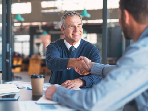 Two men shake hands in agreement.