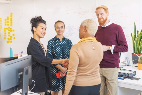 Two women shake hands during a meeting