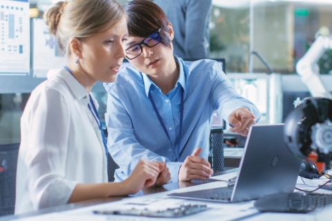 Scientists sitting at a desk reviewing coding and programming.