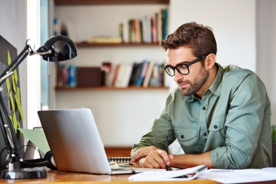 A copywriter and editor focusing on his work on a laptop.