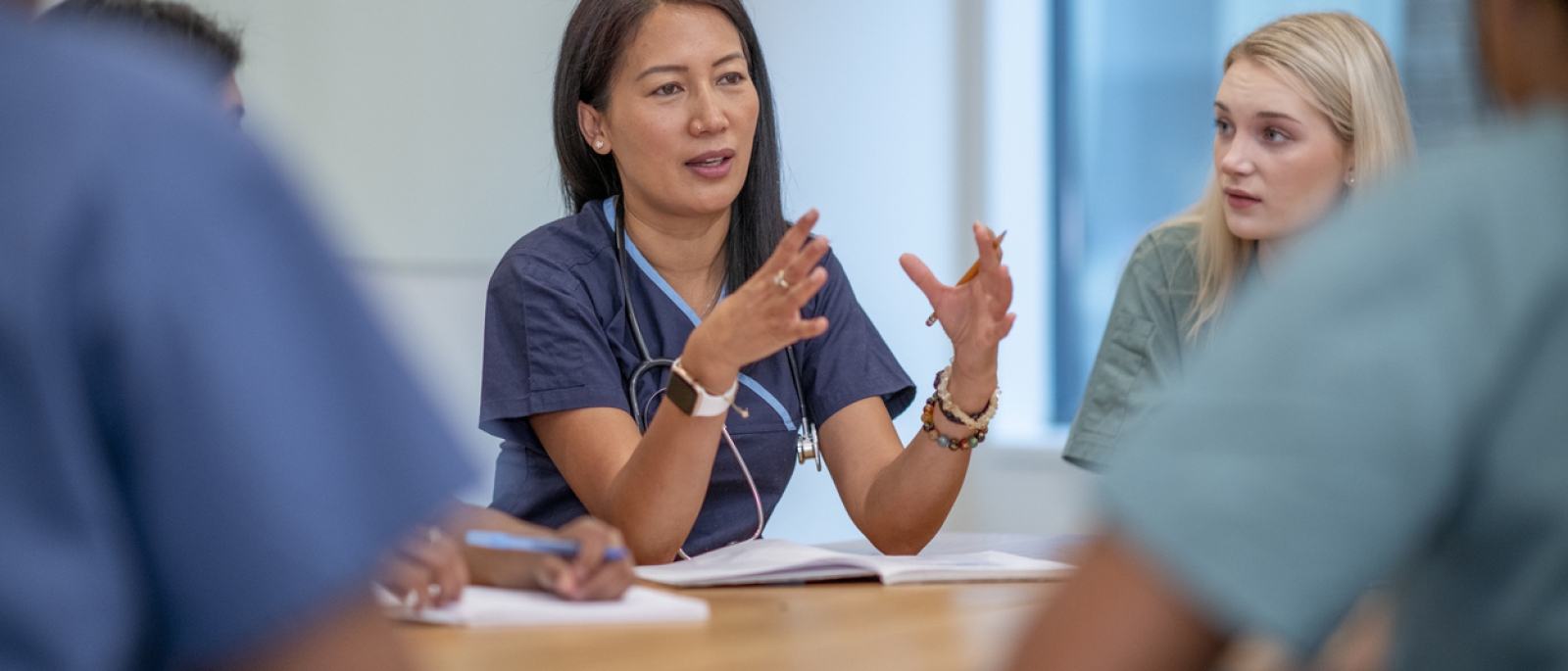 Medical professional consulting a group during a meeting.