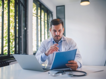A medical professional reviews documents in his office.